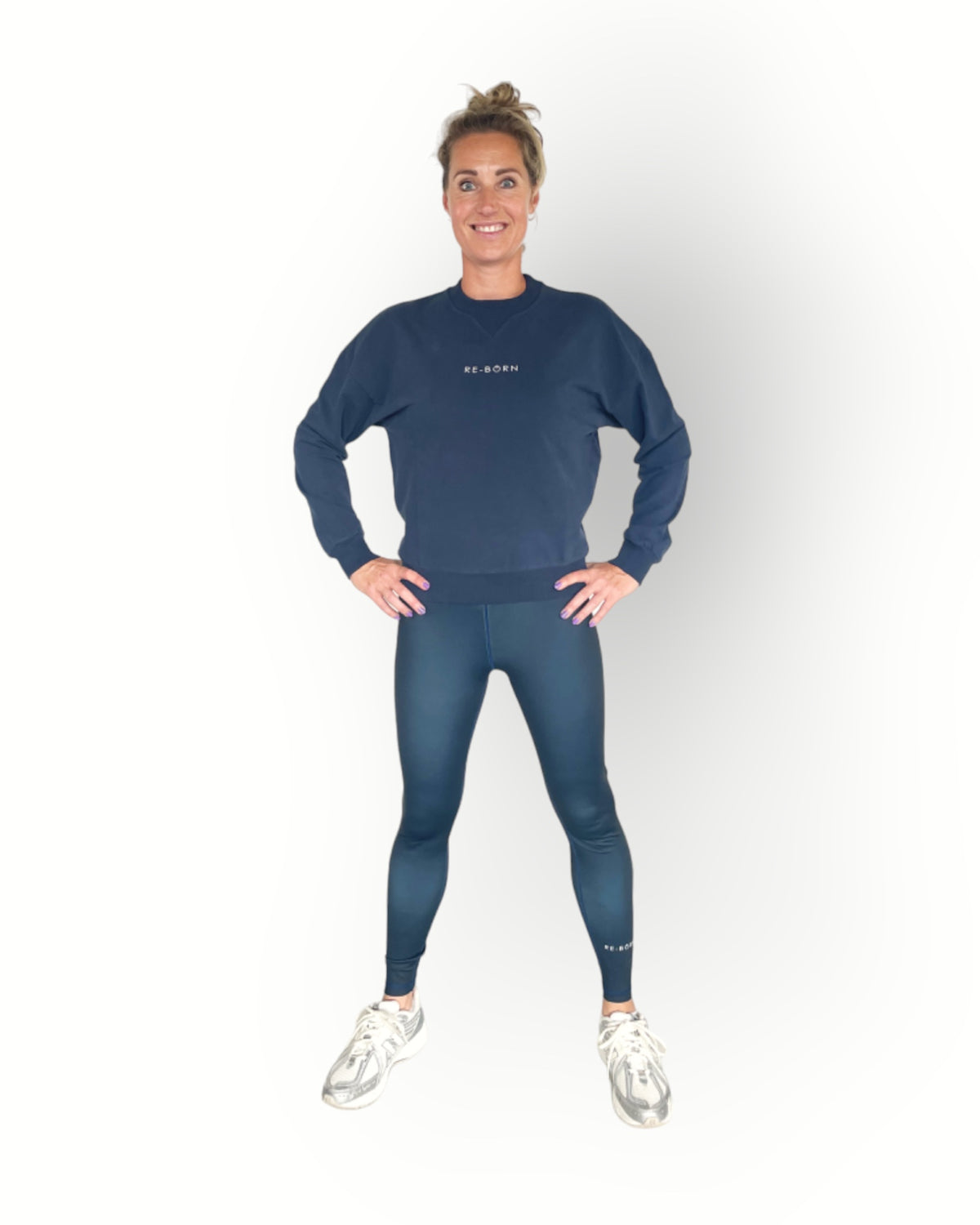 A woman wearing a navy long sleeve crew top with rib detail and a crew neckline in a super soft fabric and combined with the reversed sports legging in navy colour.