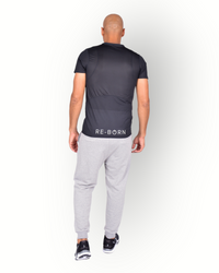 A man wearing a black mesh light weight quick dry sports top short sleeves with logo printed on the backside. 