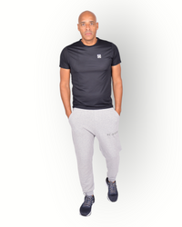 A man wearing a black mesh light weight quick dry sports top short sleeves with logo printed on the backside. 