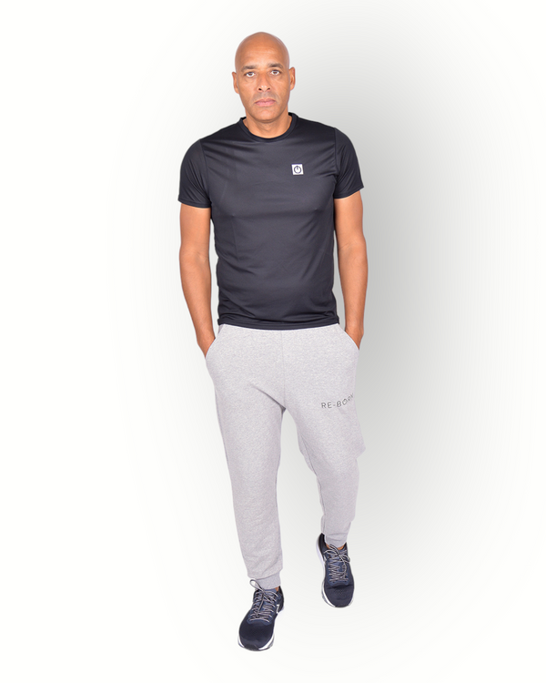 A man wearing a black mesh light weight quick dry sports top short sleeves with logo printed on the backside. 