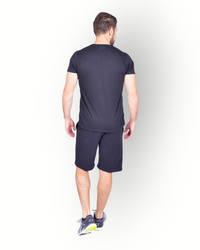A man wearing a black short sleeve T-shirt with RE-BORN logo printed on the front combined with a black fleece shorts.