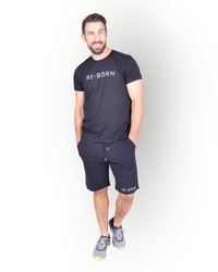 A man wearing a black short sleeve T-shirt with RE-BORN logo printed on the front combined with a black fleece shorts.