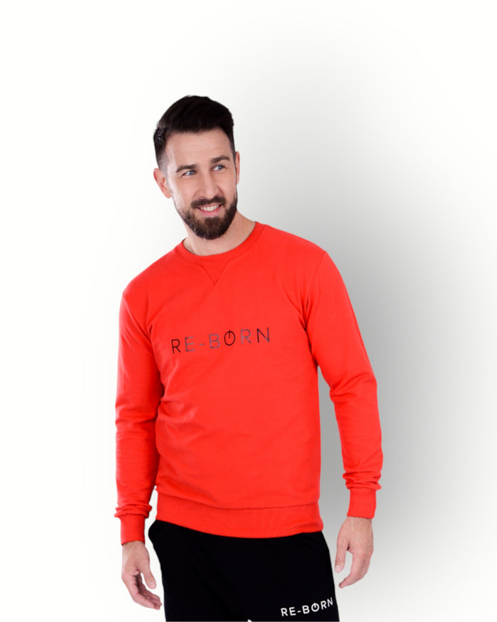 A man wearing a long sleeve red crew top with the brand name 'RE-BORN' on the front.