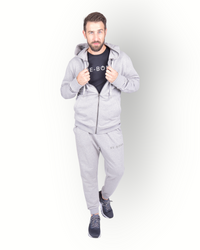 A man wearing a long sleeve full zip hooded top in grey, with side pockets and a scuba neck and printed E-BORN SPORTS on the back.
