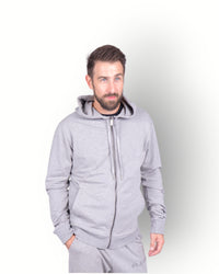 A man wearing a long sleeve full zip hooded top in grey, with side pockets and a scuba neck and printed E-BORN SPORTS on the back.