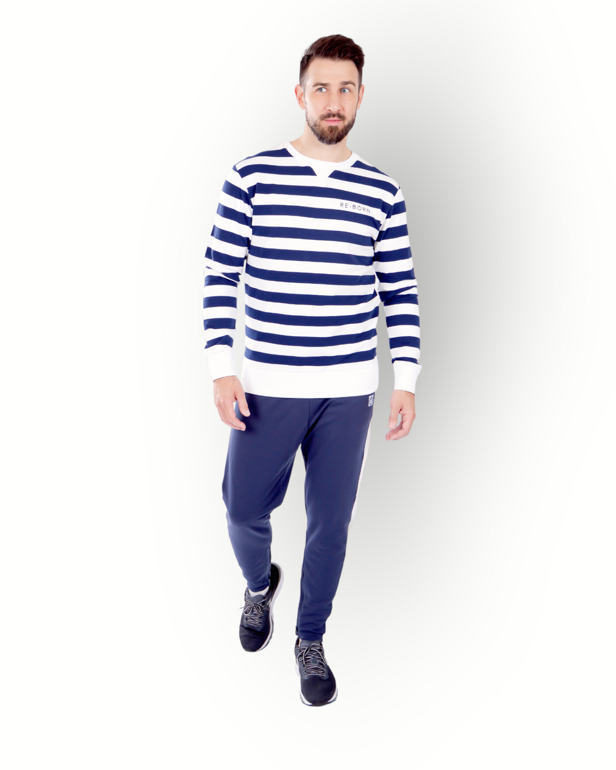 A man wearing a long sleeve navy and white striped crew top with the brand name 'RE-BORN' on the chest.
