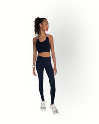 Woman wearing a black athletic outfit on a white background