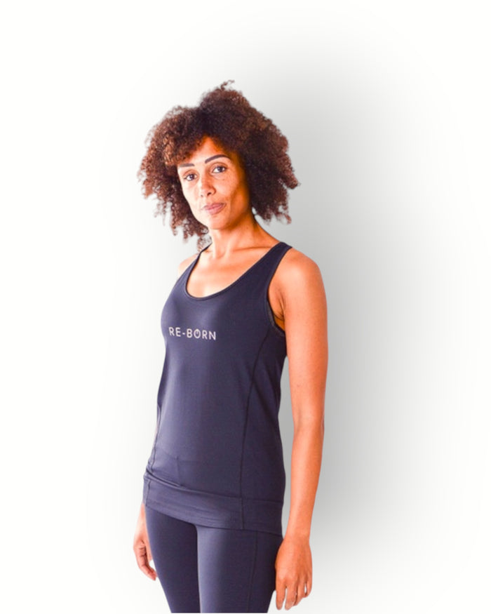 A woman wearing a black tank top with the brand name 'Re-Born' visible on the chest area, standing with hands on hips against a white background.