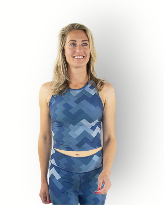 A woman wearing a sleeveless camo blue print sport crop top combined with reversible printed legging.
