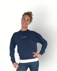 A woman wearing a navy long sleeve crew top with rib detail and a crew neckline in a super soft fabric.