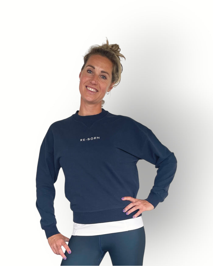 A woman wearing a navy long sleeve crew top with rib detail and a crew neckline in a super soft fabric.